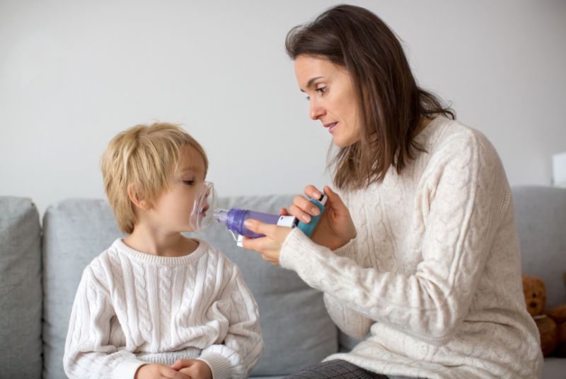 Child being given asthma puffer by parent