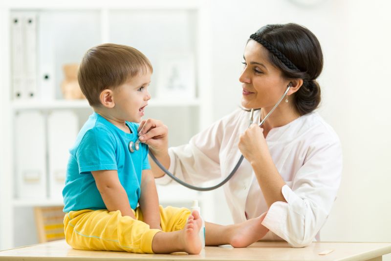 Doctor listening to child's heartbeat