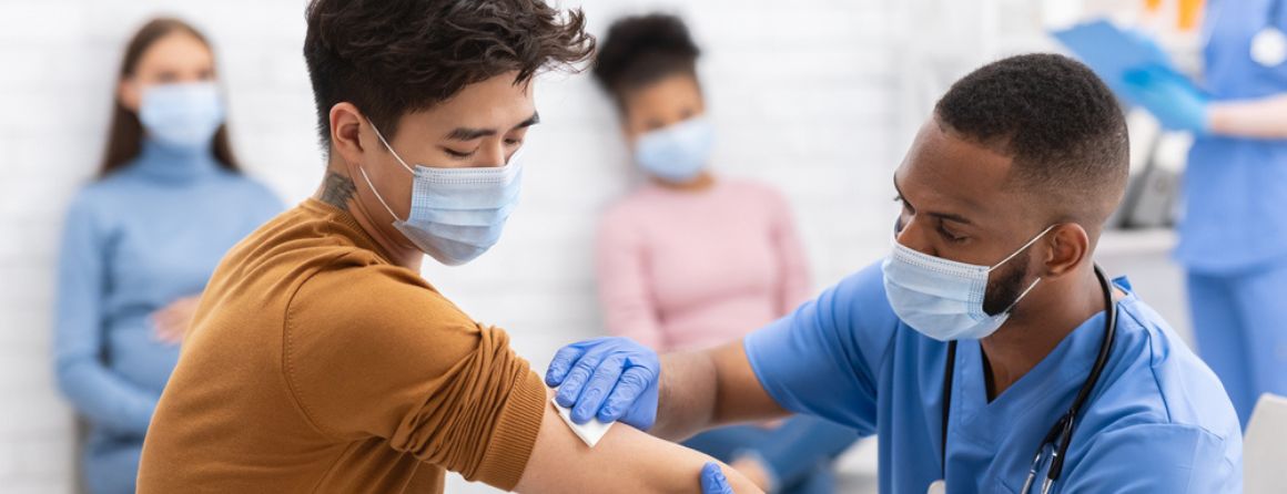 A COVID-19 vaccine is administered by a doctor to a patient