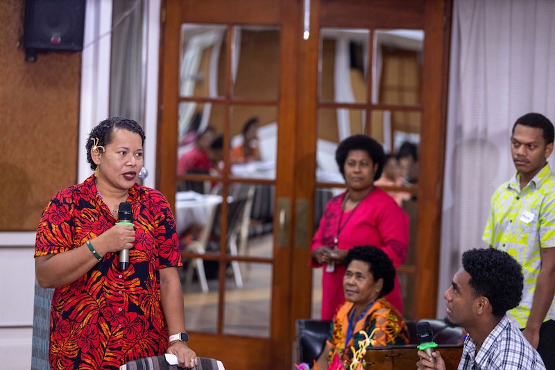 A woman speaks in Fiji about vaccines