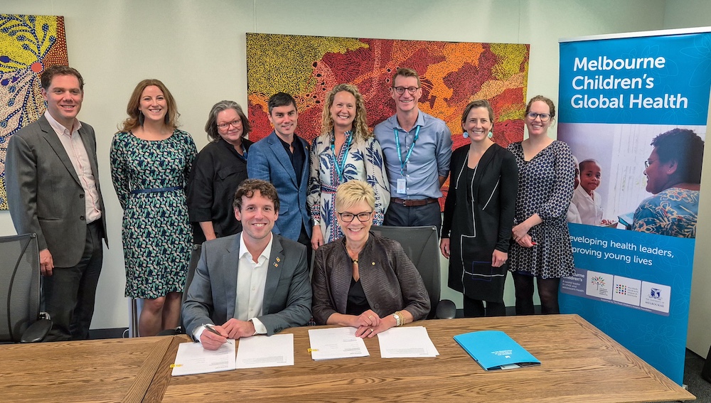 Dr Lucas de Toca, Australia's Ambassador for Global Health, signing the agreement with MCRI Director Professor Kathryn North AC alongside the MCRI Global Health team.