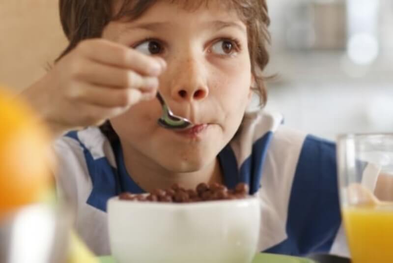 Young boy eating cereal.