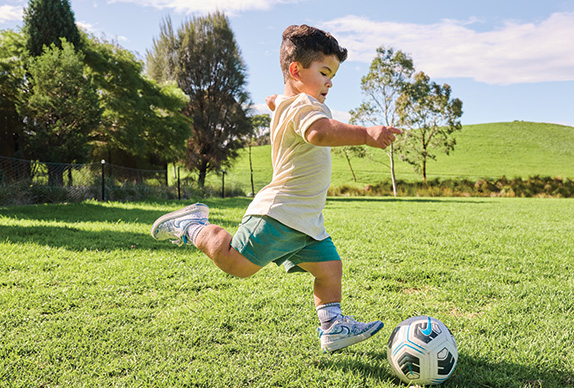 Child with achondroplasia kicking a soccer ball