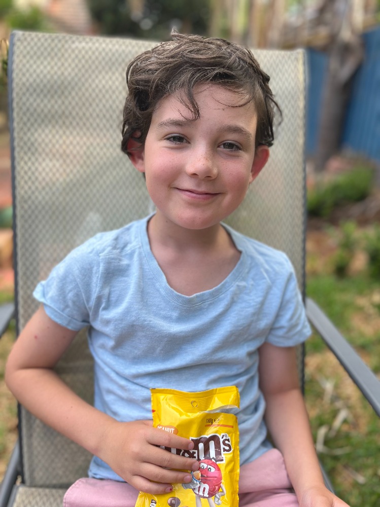 a boy with a bag of peanut m&ms