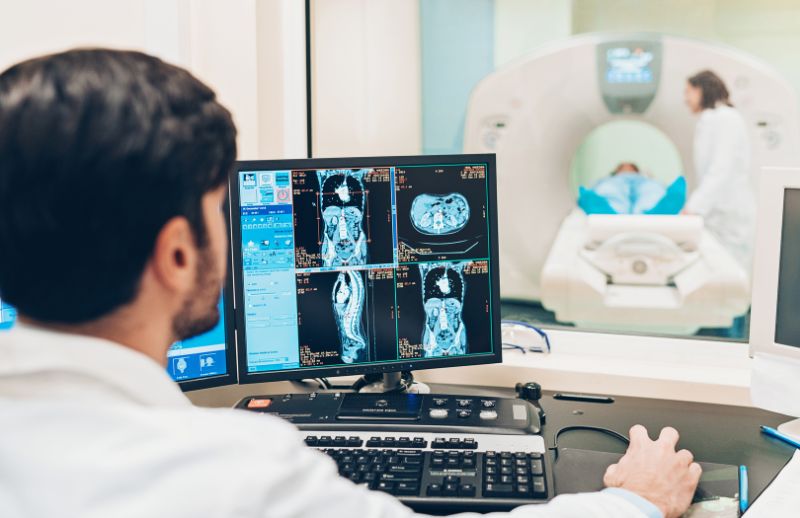 Doctor reviewing scan information of patient in MRI facility