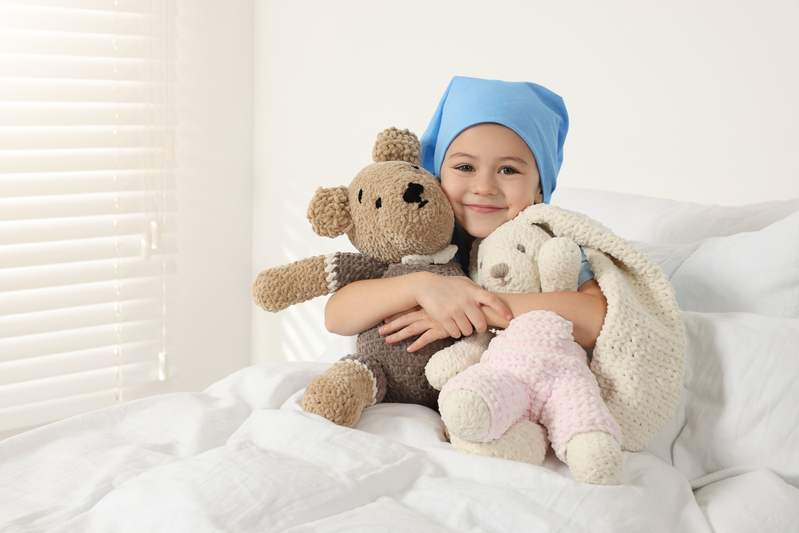 Child with cancer hugging stuffed animals