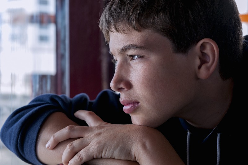 Teenager looking out of window