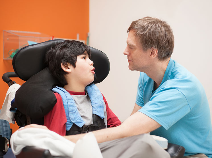 Man talking to a boy in a wheelchair